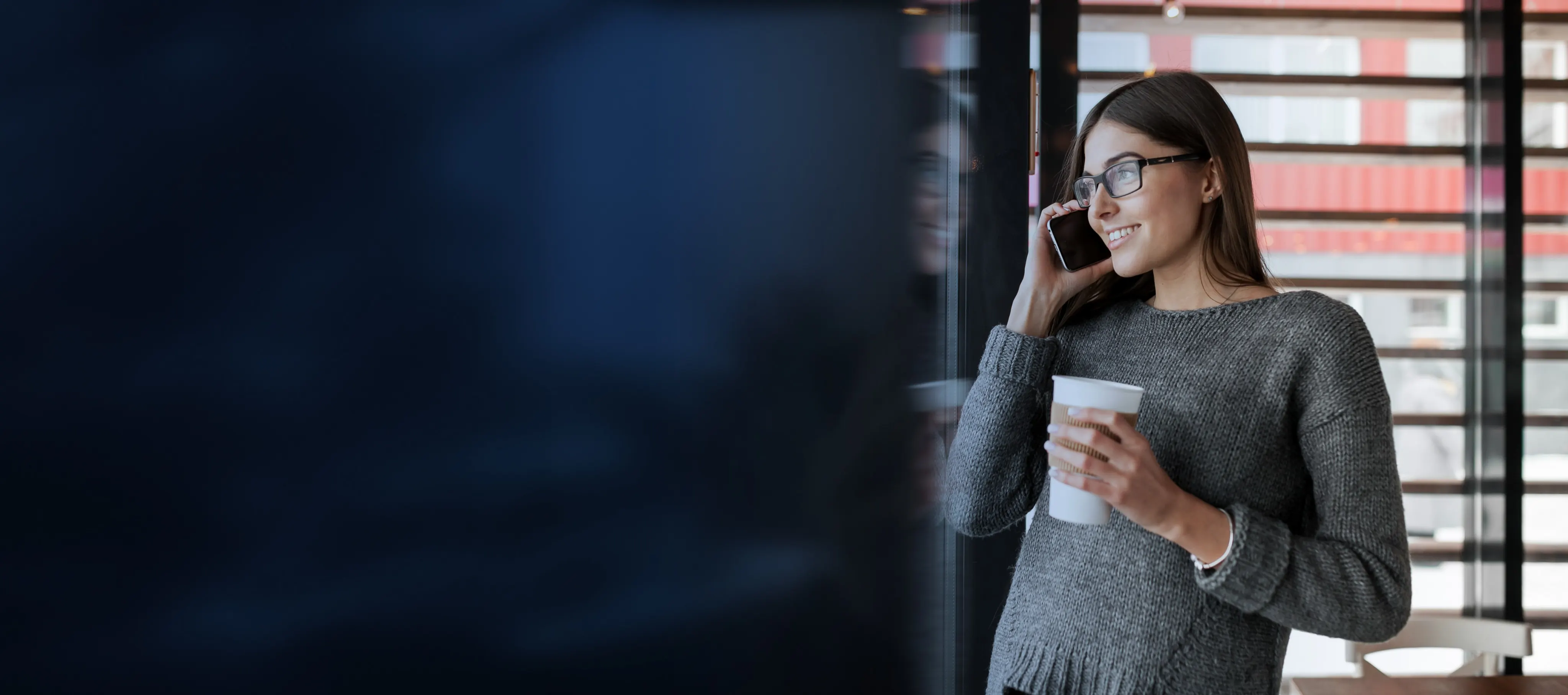 Femme à lunettes au téléphone, un café à la main